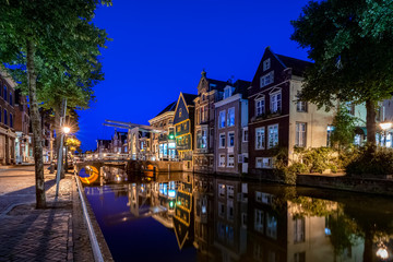 Fototapeta na wymiar The illuminated monumental medieval houses and facades in the inner city of an Authentic Dutch old city center in Holland