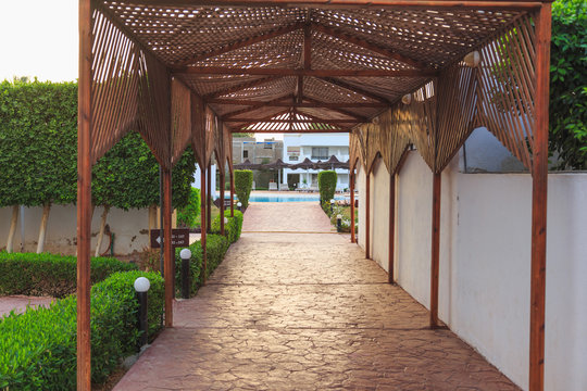 passage to the pool under a wooden gazebo
