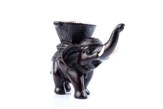 Black elephant made of resin like wooden carving with candle holder with white ivory. Stand on white background, Isolated, Art Model Thai Crafts, For decoration Like in the spa. Engraved pattern.