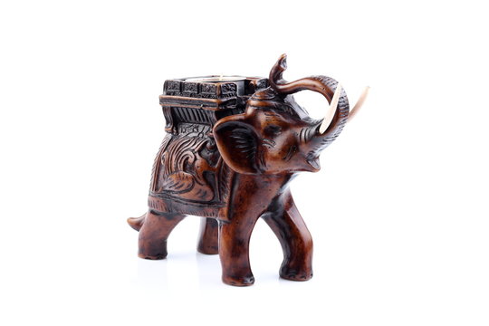 Brown Gold Black elephant made of resin like wooden carving with candle holder with white ivory. Stand on white background, Isolated, Art Model Thai Crafts, For decoration Like in the spa. Engraved pa