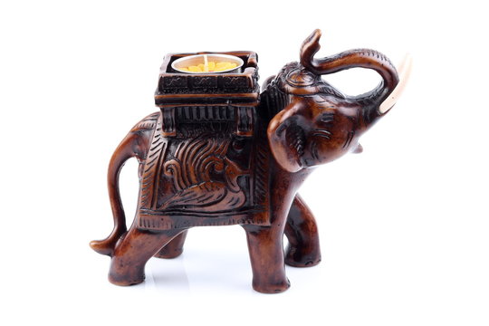 Brown Gold Black elephant made of resin like wooden carving with candle holder with white ivory. Stand on white background, Isolated, Art Model Thai Crafts, For decoration Like in the spa. Engraved pa