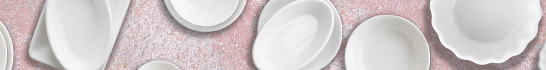 Different white porcelain dishes set on pink stone background. Concept of cooking, food,...