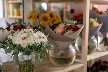 Flower shop concept. Different varieties fresh spring flowers in refrigerator room for flowers. Bouquets on shelf, florist business.