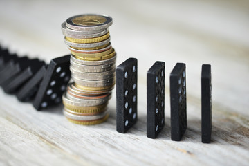 Strong currency or economy concept with pile of coins stopping the fall of black domino blocks
 - obrazy, fototapety, plakaty