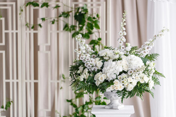 Fototapeta na wymiar Wedding decoration, ceremony in a light tent. Gorgeous bouquet of different flowers. White floral arrangement in vintage vase.