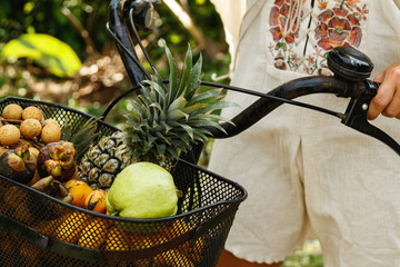 Basket on the bicycle full of different exotic fruits