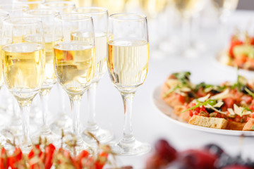 Bartender pouring champagne or wine into wine glasses on the table in restaurant. solemn wedding ceremony or happy new year banquet