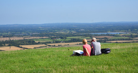 Naklejka na ściany i meble People sitting enjoying view from the South Downs East Sussex