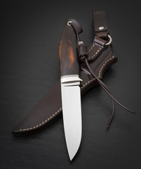 Hunting knife handmade on a black background. Leather Sheath Handmade