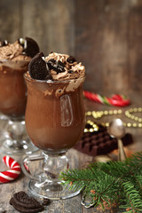 Festive hot chocolate with whipped cream and cookies.