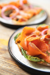 Delicious toasts with smoked salmon, avocado and basil leaves