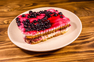 Ceramic plate with cheesecake on wooden table