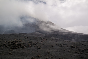 Etna vulcano surrealistic landscape mountain clouds fog lava stone 