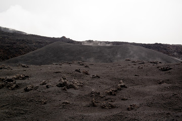 Etna vulcano surrealistic landscape mountain clouds fog lava stone 