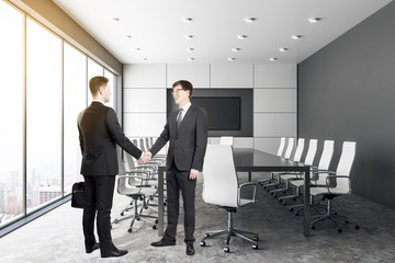 Handshake in contemporary conference room