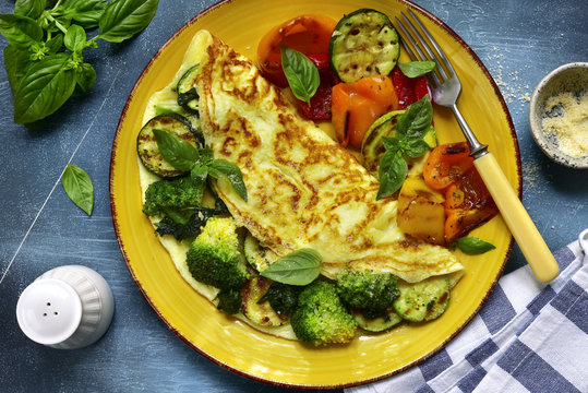 Omelette stuffed with green vegetables (broccoli, zucchini, spinach) garnished with grilled bell pepeer.Top view.