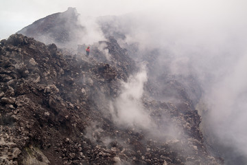 Fototapeta na wymiar Etna vulcano surrealistic landscape mountain clouds fog lava stone 