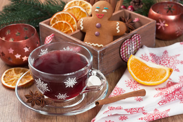 Mulled wine / Mulled wine winter hot drink in glass cup with cinnamon, dried orange slices, anise star, spices, gingerbread cookies on wooden background