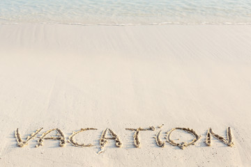 Handwritting inscription Vacation word on beach
