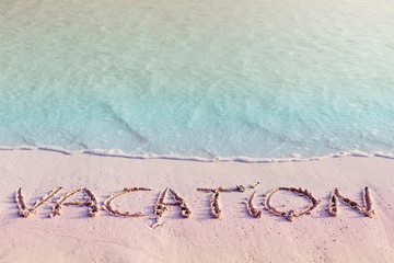Handwritting inscription Vacation word on beach