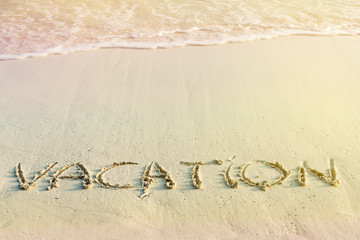 Handwritting inscription Vacation word on beach