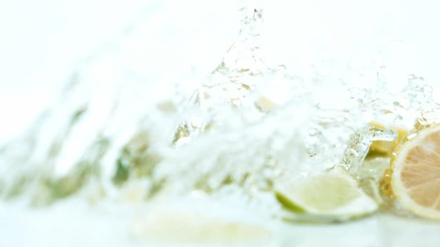 Super slow motion of limes and lemons with water splash on white background. Filmed on high speed cinema camera Phantom VEO 4k, 1000 fps.