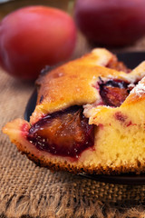 A piece of homemade pie baked in the oven with plums. close-up, vertical frame.