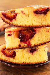 Pieces of homemade plum cake. stacked on top of each other in a stack, vertical frame, close-up.
