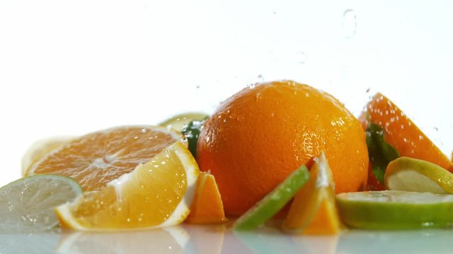 Super slow motion of limes, oranges and lemons with water splash on white background, Filmed on high speed cinema camera, 1000 fps.