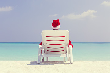 Santa Claus relaxing on sun bed, Christmas card