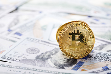 Bitcoins on dollar banknotes background