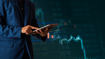 Businessman finger touching tablet with finance and banking profit graph of stock market trade...