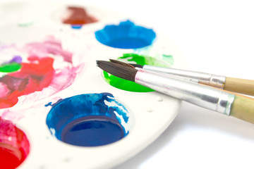 Obraz premium paintbrush lies on the palette with paints on white background