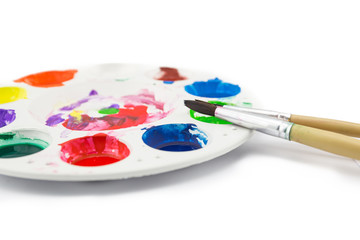 Obraz premium paintbrush lies on the palette with paints on white background