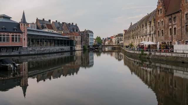 Pan motion timelapse video of the beautiful cityscape and Leie river from afternoon to sunset at Ghent, Belgium