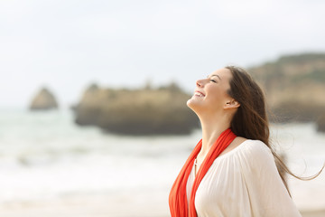 Happy woman breathing deep on the beach