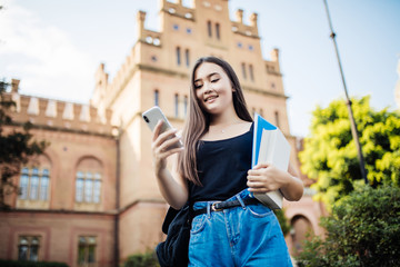 Young asian woman use of cellphone in the university campus