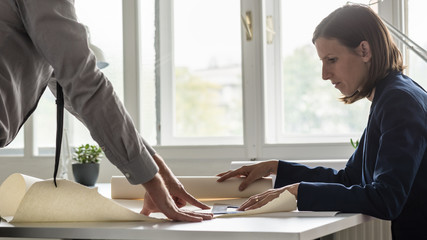Businesswoman and her partner analyzing important blueprints