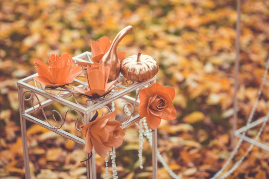 Golden pumpkin as decoration on the green and yellow leaves