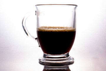 Foamy Coffee In A Glass Coffee Cup With Handle On White Background