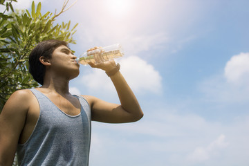 sport man drinking water after running