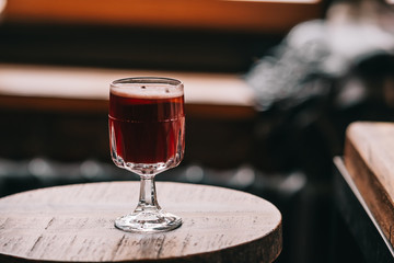 One glass of red mulled wine on wooden table. Dark food photography.