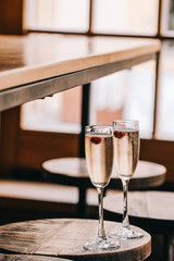 Two glasses of champaigns, Italian sparkling white wine on wooden table against window lights. Food and drink photpgraphy, copyspace, minimalism