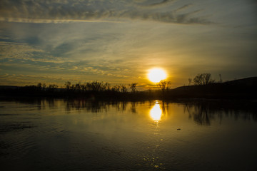 Bright Orange Sunset Over Calm River 