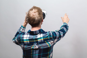 Young man using a virtual reality headset from behind