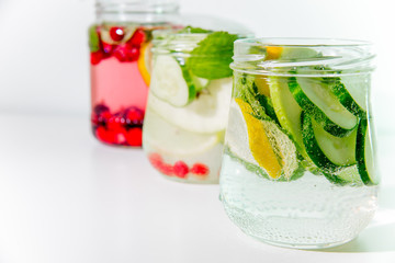 Summer drink coctail in glass jar, berries and mint on wooden table