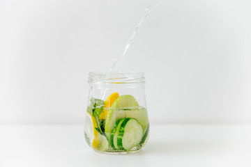 Summer drink coctail in glass jar, berries and mint on wooden table