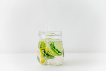 Summer drink coctail in glass jar, berries and mint on wooden table