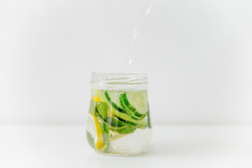 Summer drink coctail in glass jar, berries and mint on wooden table