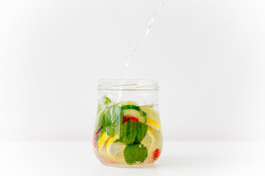 Summer drink coctail in glass jar, berries and mint on wooden table